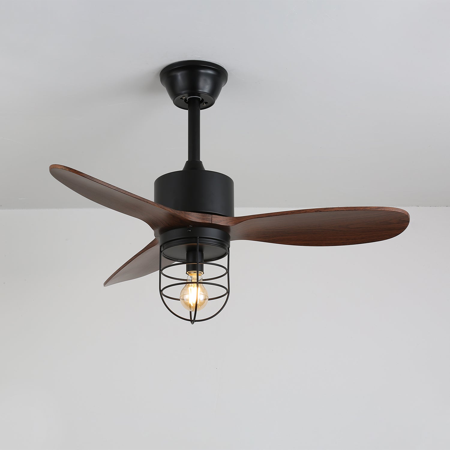 Vue rapprochée des pales en bois de noyer du ventilateur de plafond Brisora