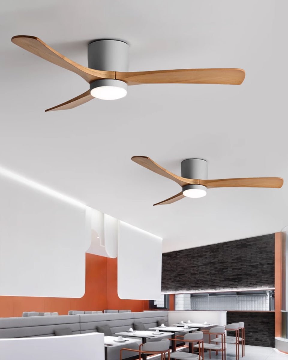 Ventilateur de plafond en bois nordique Ezra avec lumière, vu d'en bas, soulignant son esthétique minimaliste.