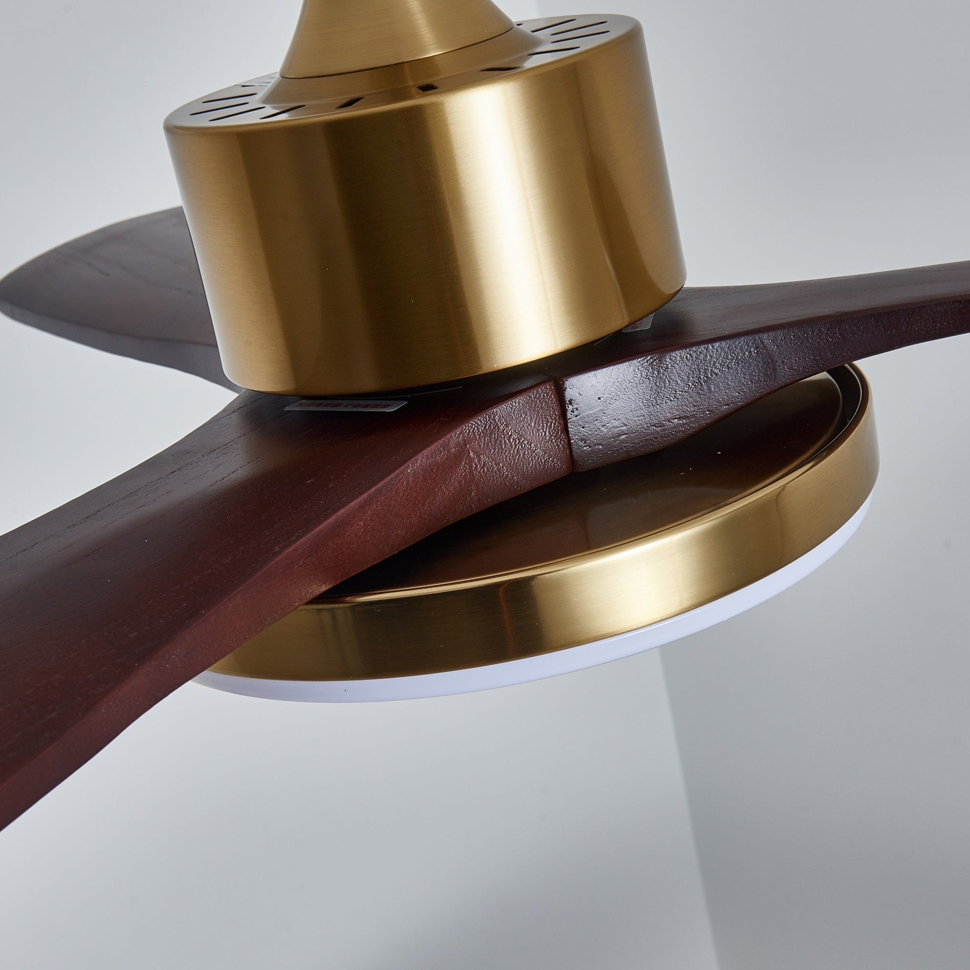 Plafonnier ventilateur Xen moderne en bois, installé sur un plafond blanc