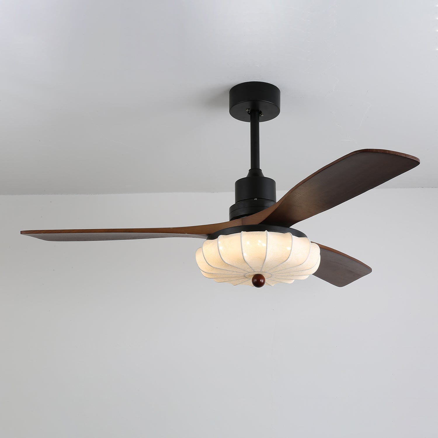 Plafonnier ventilateur Ventra Vintage en verre et bois installé dans une chambre douillette.
